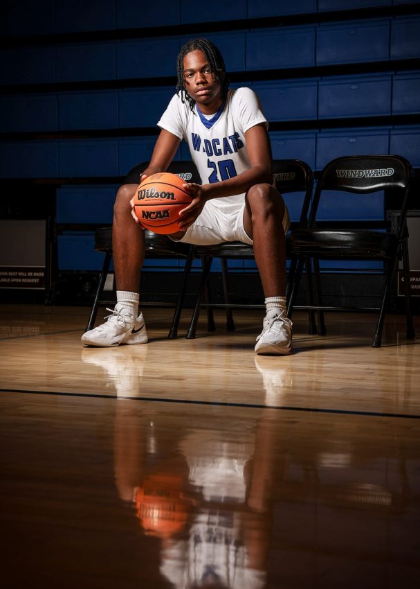 Wildcats basketball player #20 sitting on bench with Wilson basketball in gym