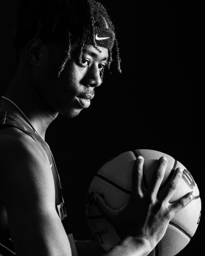 Basketball player holding ball in dramatic black and white portrait